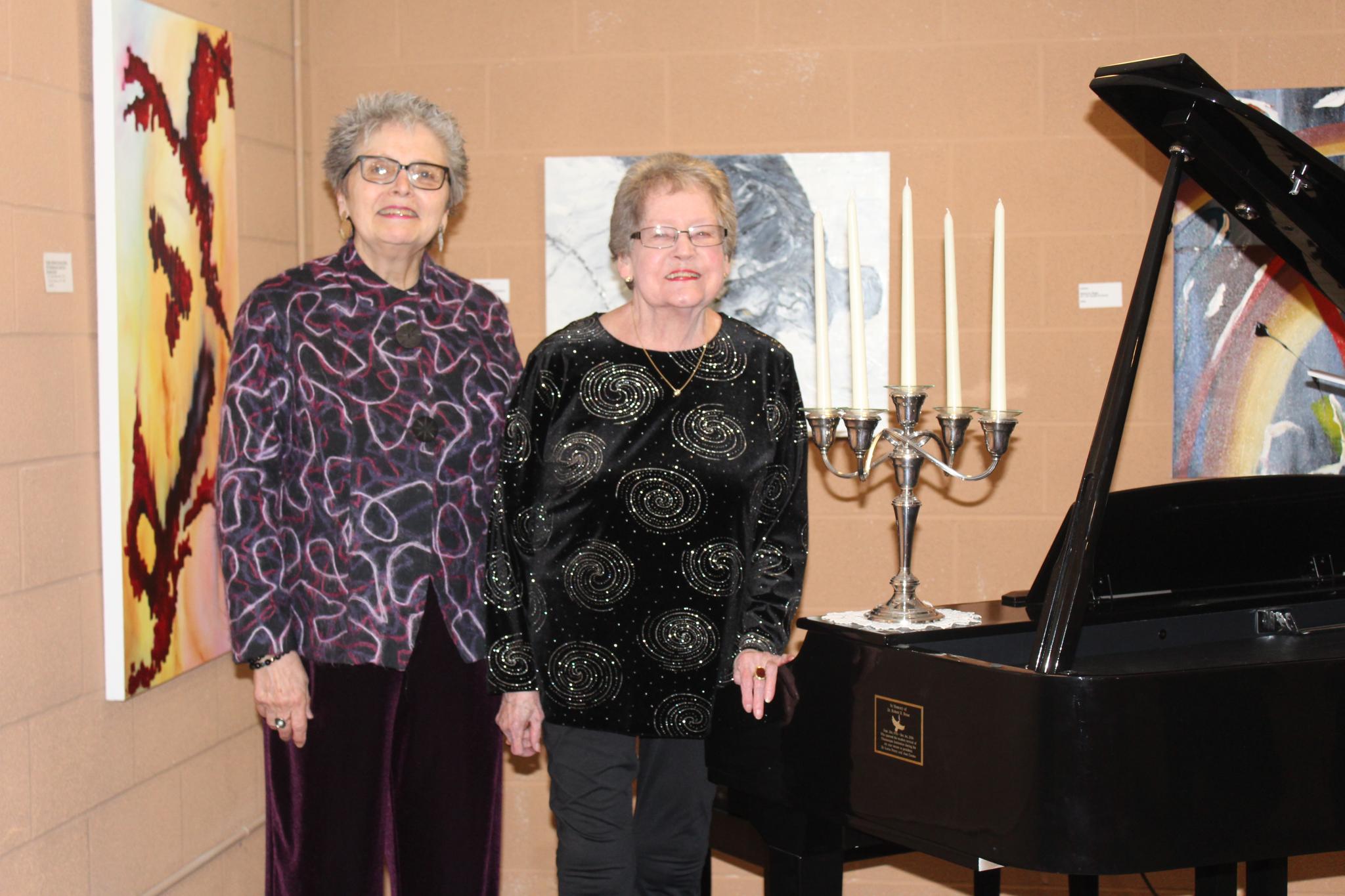 Joan Caruso and Lorna Penny with the grand piano they donated in the name of Dr. Robert R. Hesse
