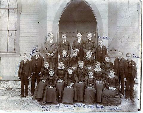 German Confirmation Class 1892 or 1893 on Chestnut St. also known as St. Peters German Church. Some names from back (hard to read): Louise Brant (Mrs. John Kolpien) Amelia Storm, Augusta Piehl, Donna Piehl, Ben Miller, John Kolpien. Some more names from front: Keopka (female front right), H Hardee (male on right), D Foote (female 3rd from right, front).