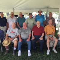 Group photo taken 7-8-18 at Ottaway Park: Back row left to right: Dave Turner (driver), Ron Blackmer (driver), Wally Howser (son of driver Jim Howser), John Swartout (son of original builder and owner of Coon Road Speedway, Joel Swartout), Skip Furlow (driver), Bill Catania (builder of #18 replica race car). Front row left to right: Emma Strain (widow of driver Don Strain), Ken See (driver), Al Brumagin (driver), Russ Weise (driver), Ray Sonnenberg (driver), Sean Hardy (current property owner of the site of